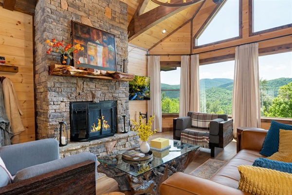 Your luxe mountain getaway awaits! Cozy living room with wood burning fireplace and jaw dropping views!