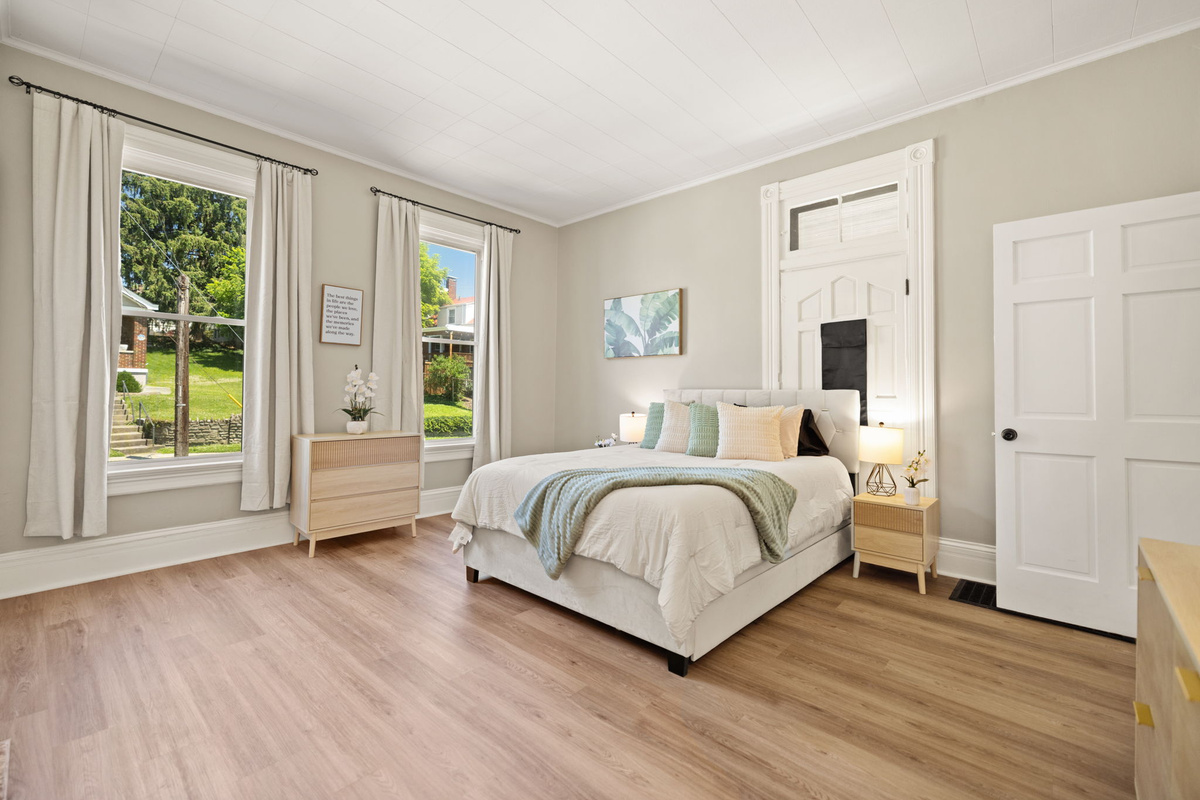 Bright, airy bedroom with oversized windows and fresh linens.