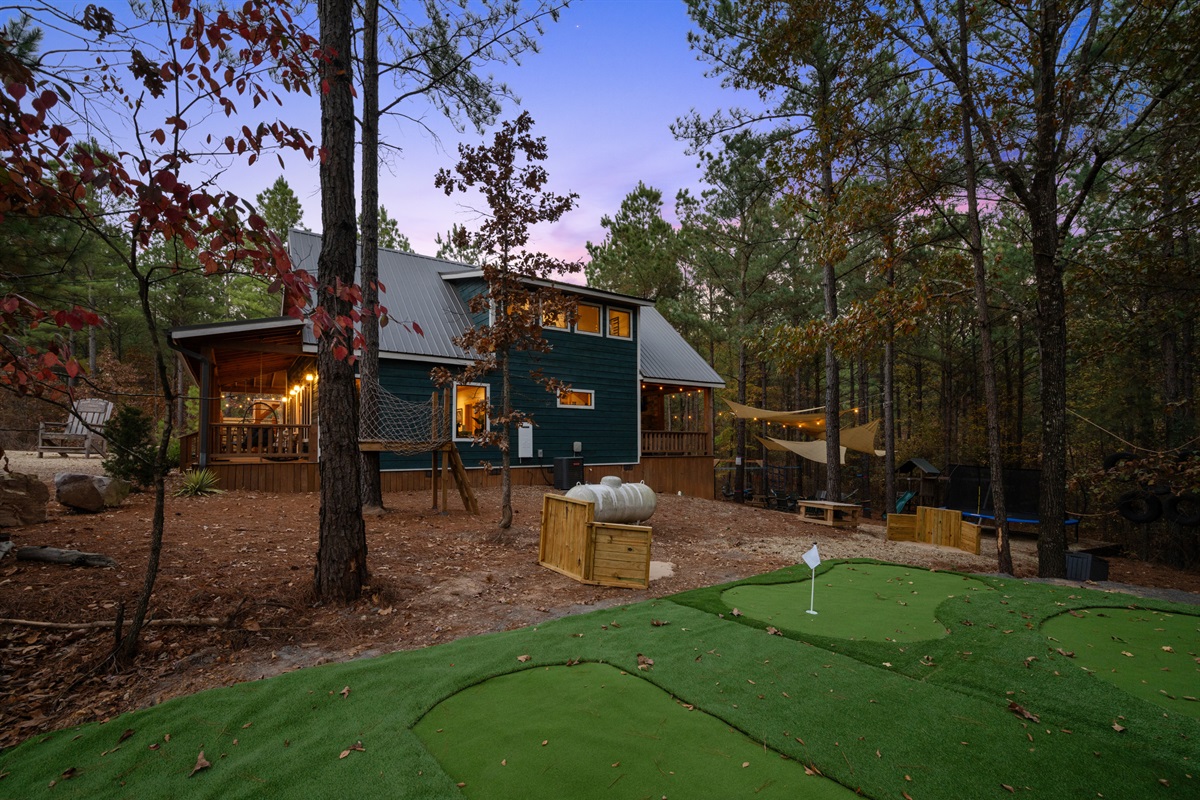 As evening settles in, the cabin lights up beautifully and creates a warm, welcoming glow across the whole outdoor space.