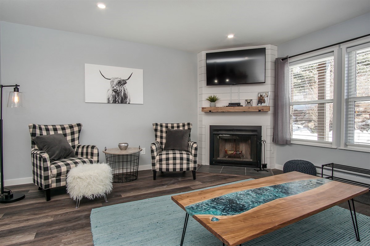 Cozy up by the fire with comfortable chairs and a warm, inviting atmosphere.