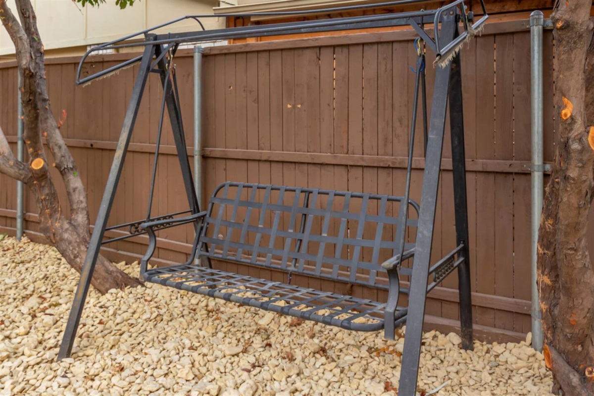 Cozy shaded swing in the garden, perfect for relaxing between dips in the pool.
