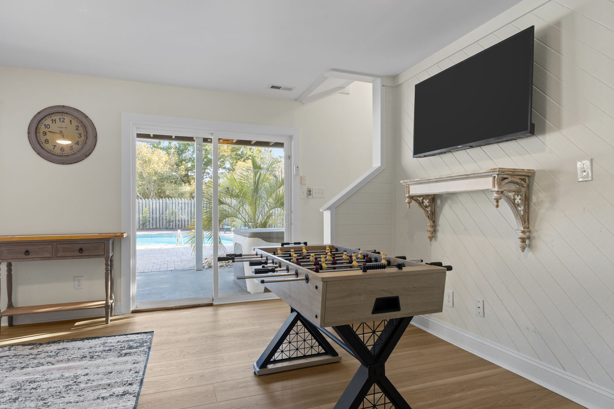 Gather in the spacious ground floor living area featuring comfortable seating, a large Smart TV, and direct access to the private pool and patio