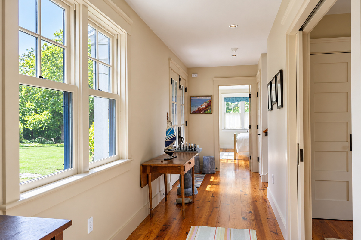 Sunlit hallway with wide pine floors