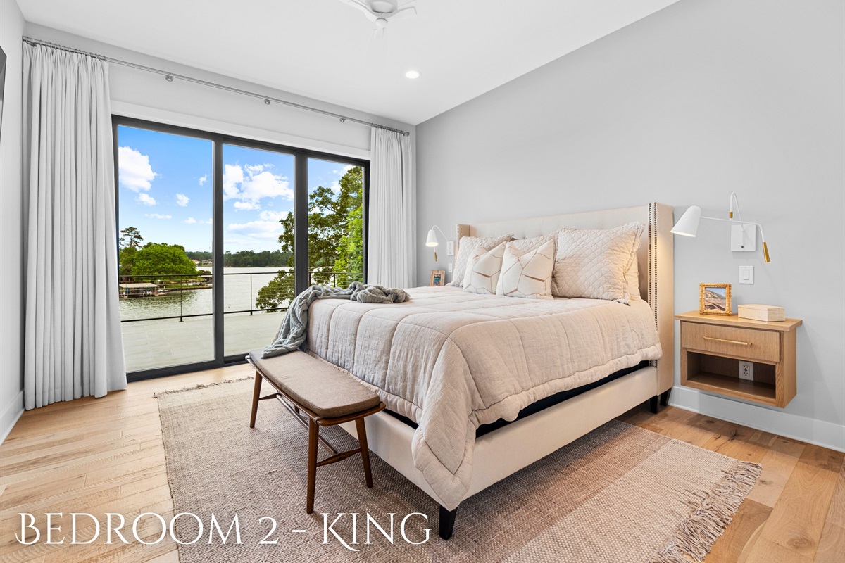 Enjoy the comfort and elegance of this king bedroom, featuring plush bedding and expansive windows.