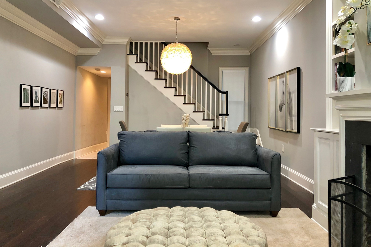 Open-concept living with a queen sofa bed, tufted ottoman, and elegant dining space—perfect for relaxing, entertaining, or unwinding in style.