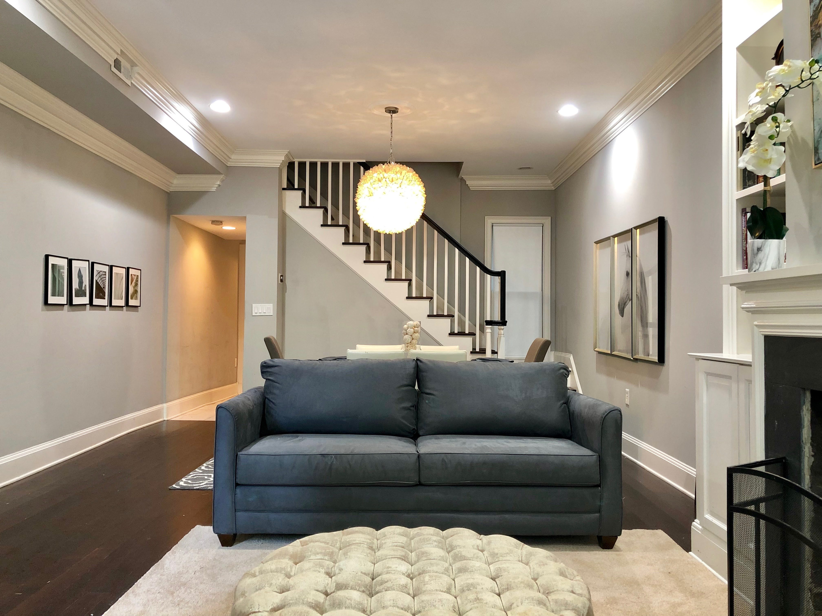 Open-concept living with a queen sofa bed, tufted ottoman, and elegant dining space—perfect for relaxing, entertaining, or unwinding in style.