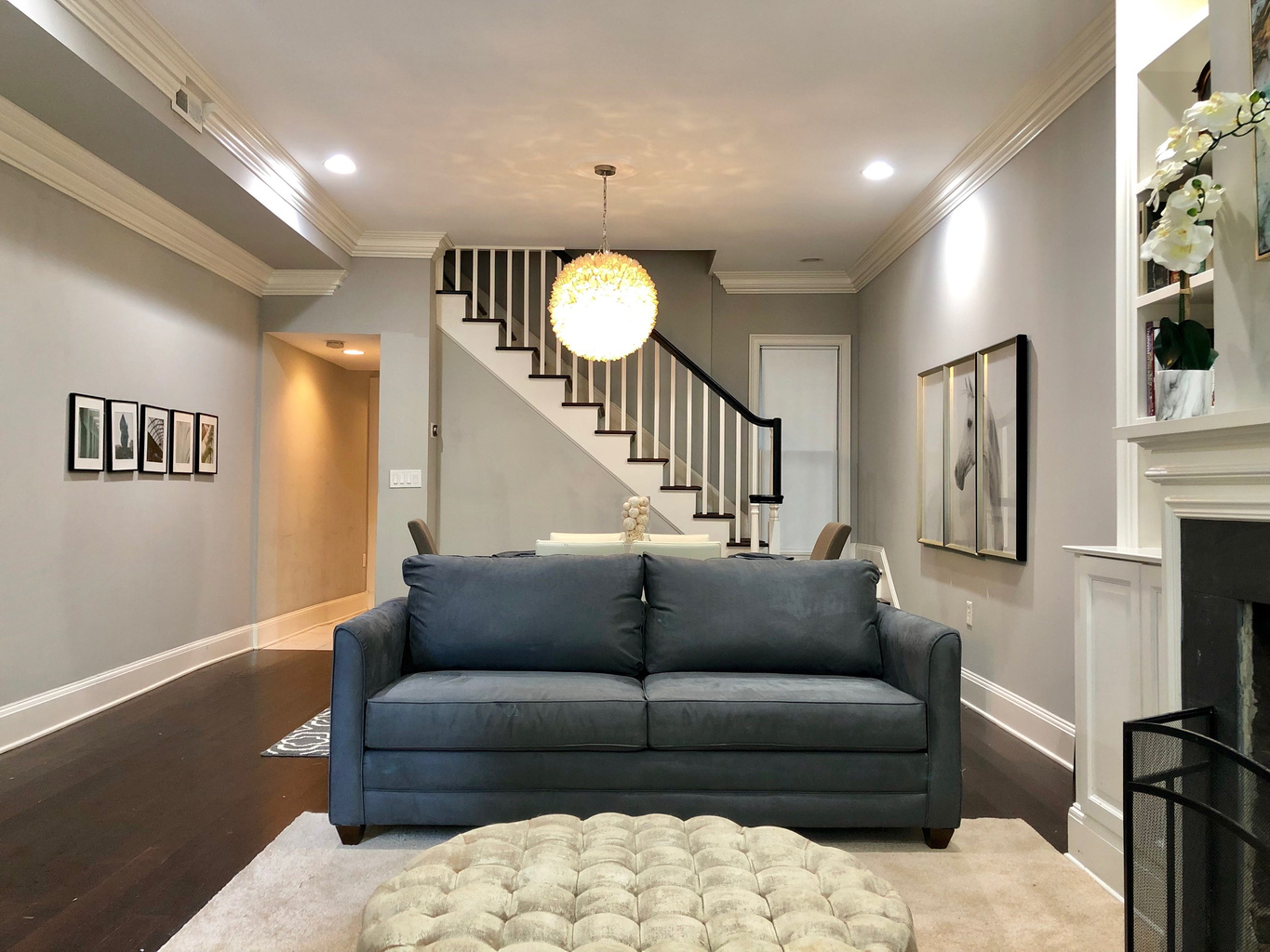Open-concept living with a queen sofa bed, tufted ottoman, and elegant dining space—perfect for relaxing, entertaining, or unwinding in style.