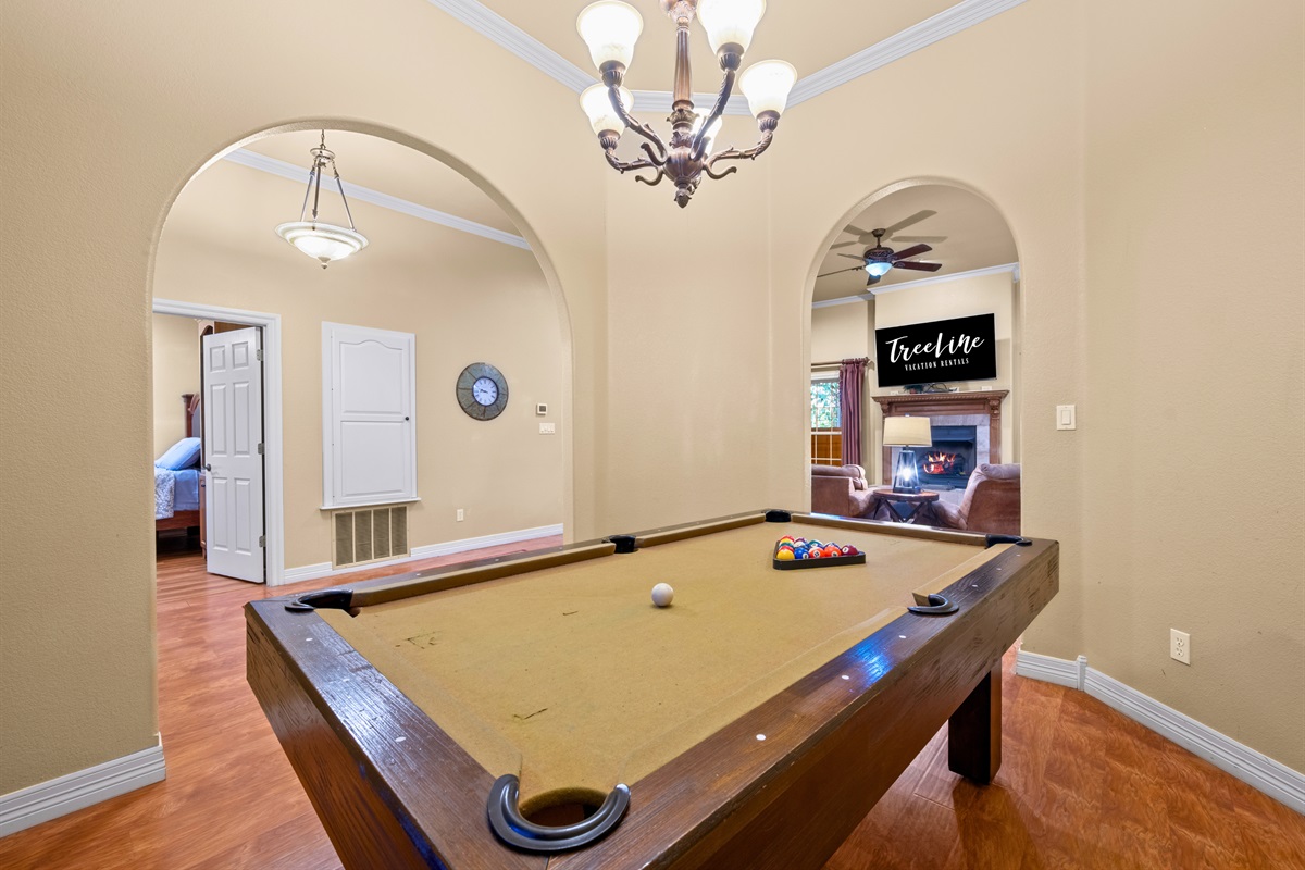 Pool table room with arched entryways and decor.