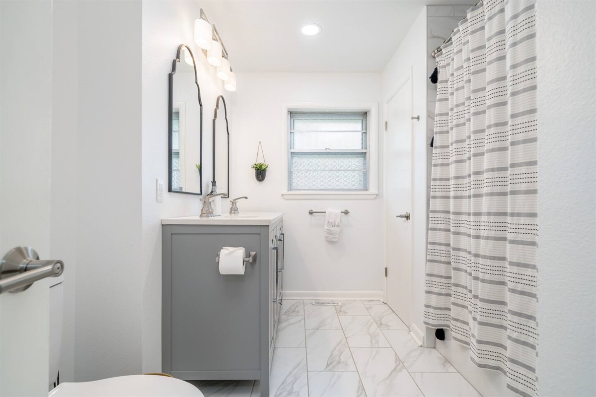 Bathroom with shower and tub with  Luxury towels, body wash and shampoo.