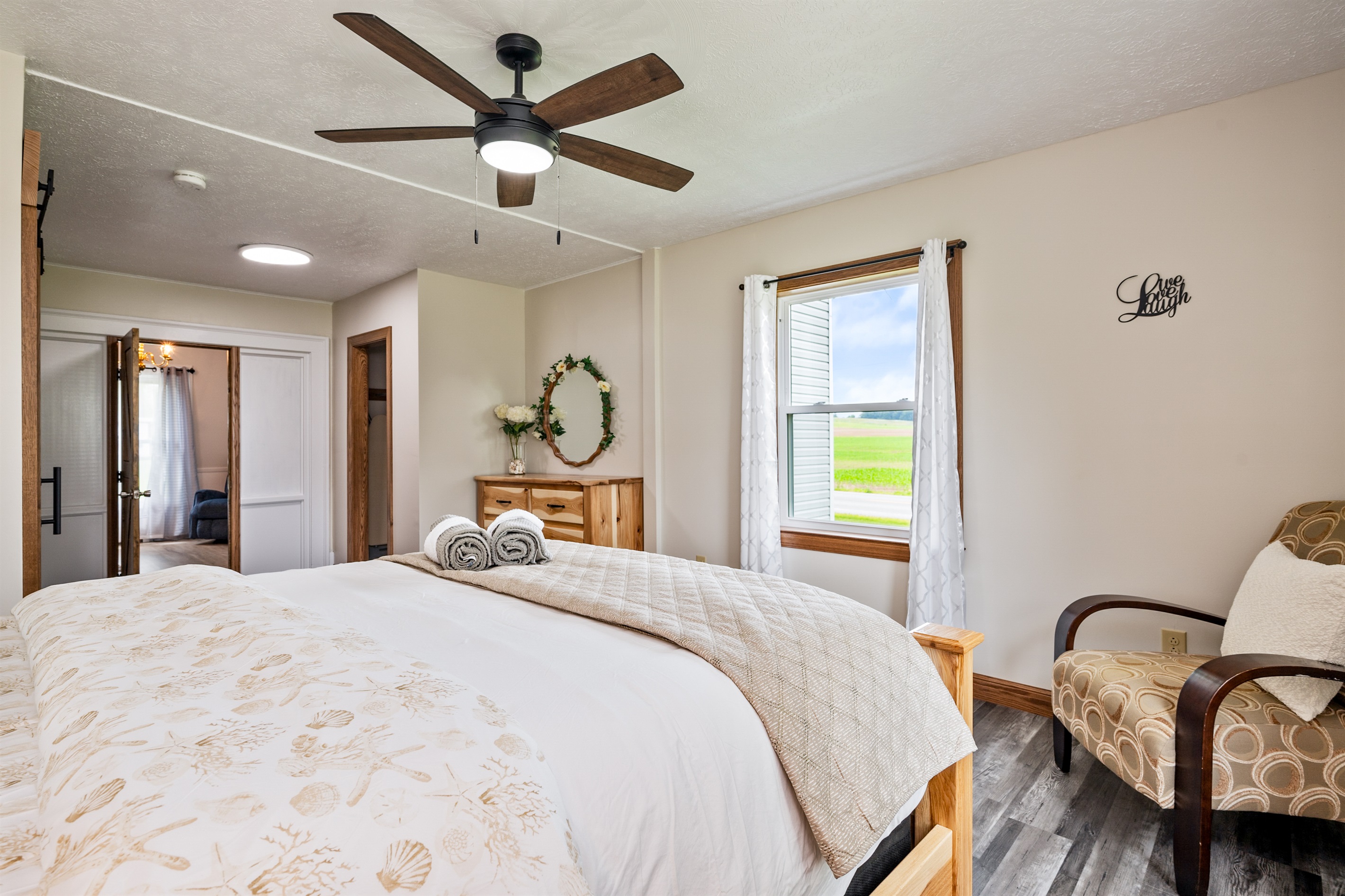 Spacious bedroom retreat with serene farmland views, fresh linens, and thoughtful decor touches.