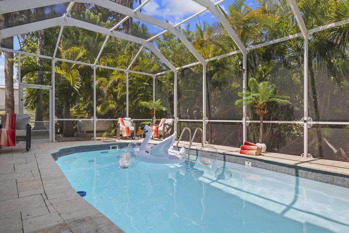 The entire pool is surrounded by palm trees.  