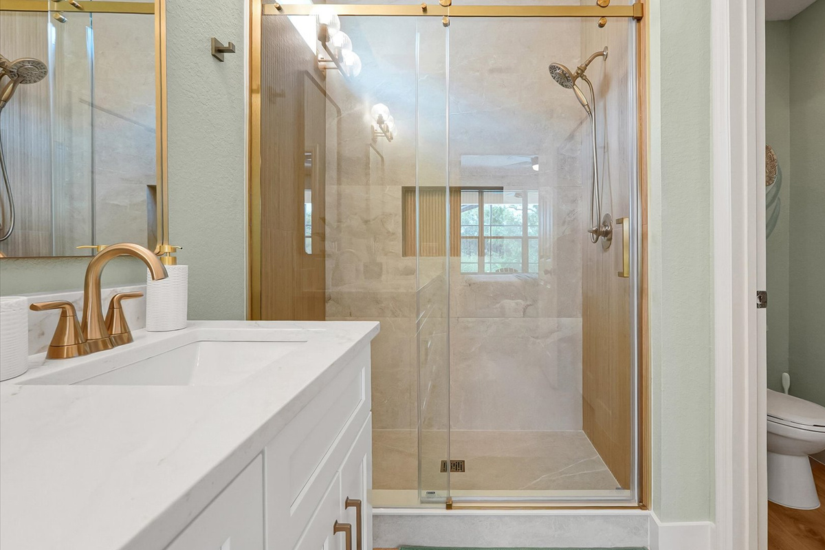 Moana King Suite Ensuite: Custom-tiled walk-in shower with a handheld showerhead and separate toilet room.