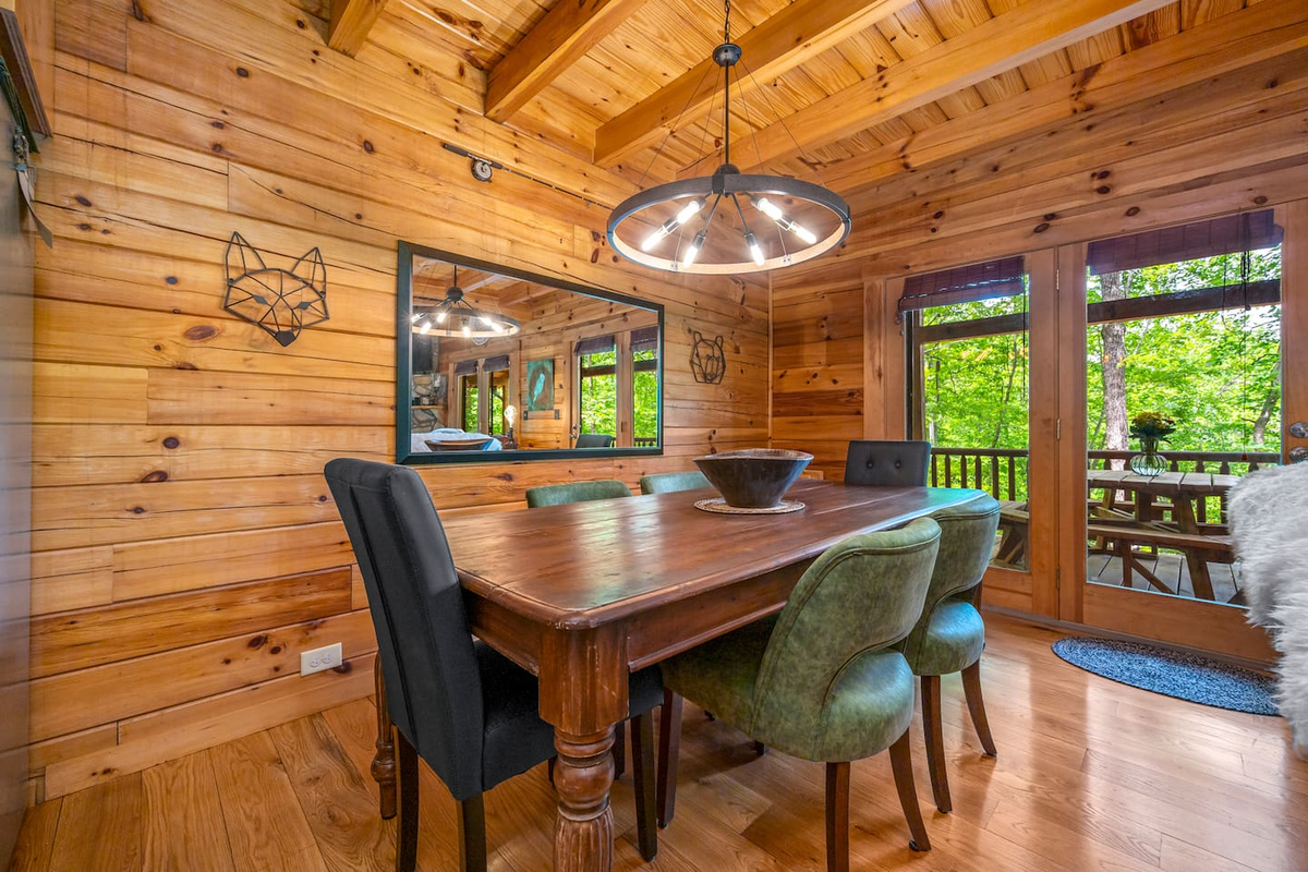 Cozy dining area with warm wood accents, stylish seating, and peaceful wooded views just outside the door. This room is a great spot for shared meals, coffee mornings, and game nights in the mountains.