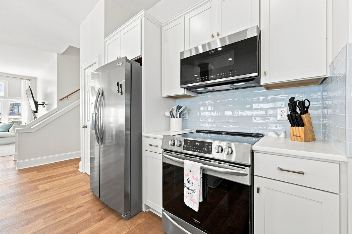 Sleek stainless steel appliances add a modern touch to this bright, open kitchen designed for gathering and entertaining.