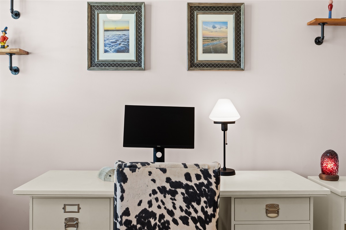 Comfortable desk setup with beach‑themed art — perfect for remote workers.
