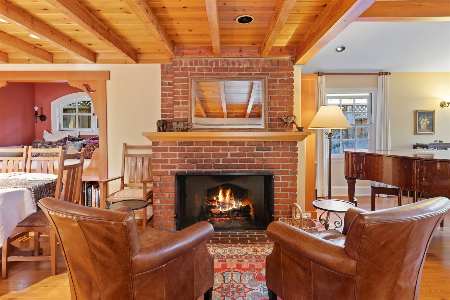Wood-burning fireplace, grand piano, and dining area