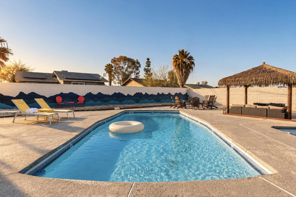 Your private pool at golden hour: sun loungers, a hand-painted mountain mural and a palapa lounge in Twentynine Palms, CA