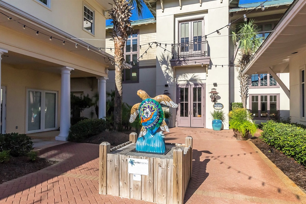 The vibrant heart of The Beach Club Resort entrance: The Village Square. Discover a delightful array of restaurants, amenities, and stores, all conveniently located to enhance your stay.