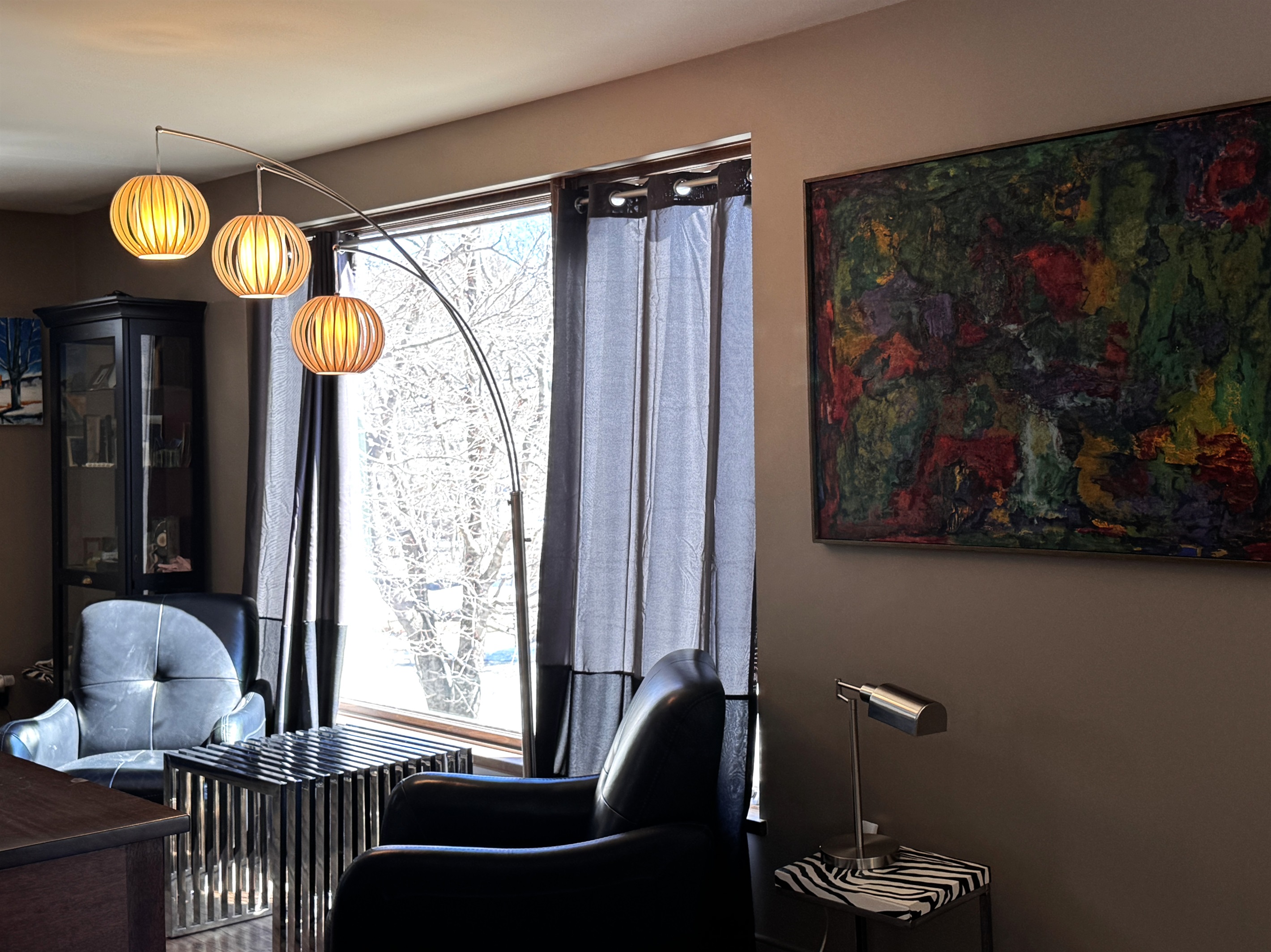A second sun-filled sitting area on the main floor, featuring modern lounge seating and designer lighting. This quiet nook offers peaceful views of historic Otter Creek village, providing the perfect space for morning reading or private conversation.
