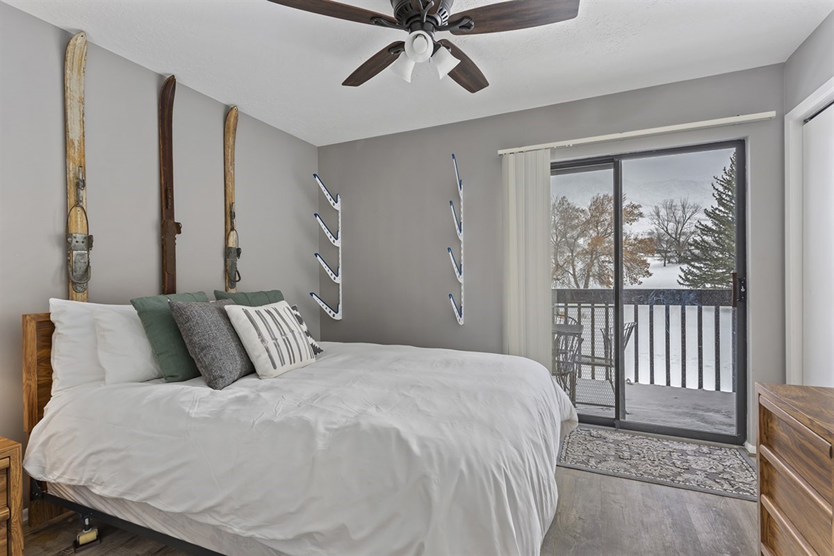 Cozy main-level queen bedroom with soft linens and private balcony access—wake up to fresh mountain air.
