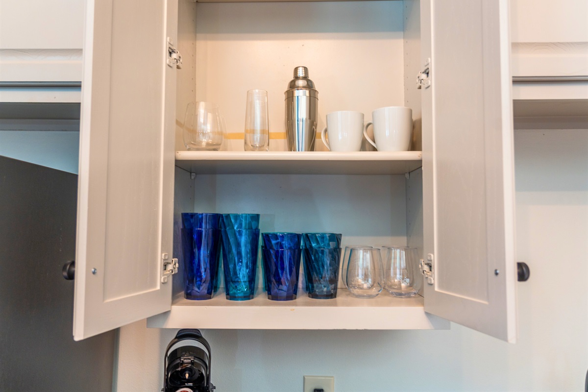 Cabinet shelves neatly arranged with glassware and mugs, providing everything you need to enjoy drinks or morning coffee.