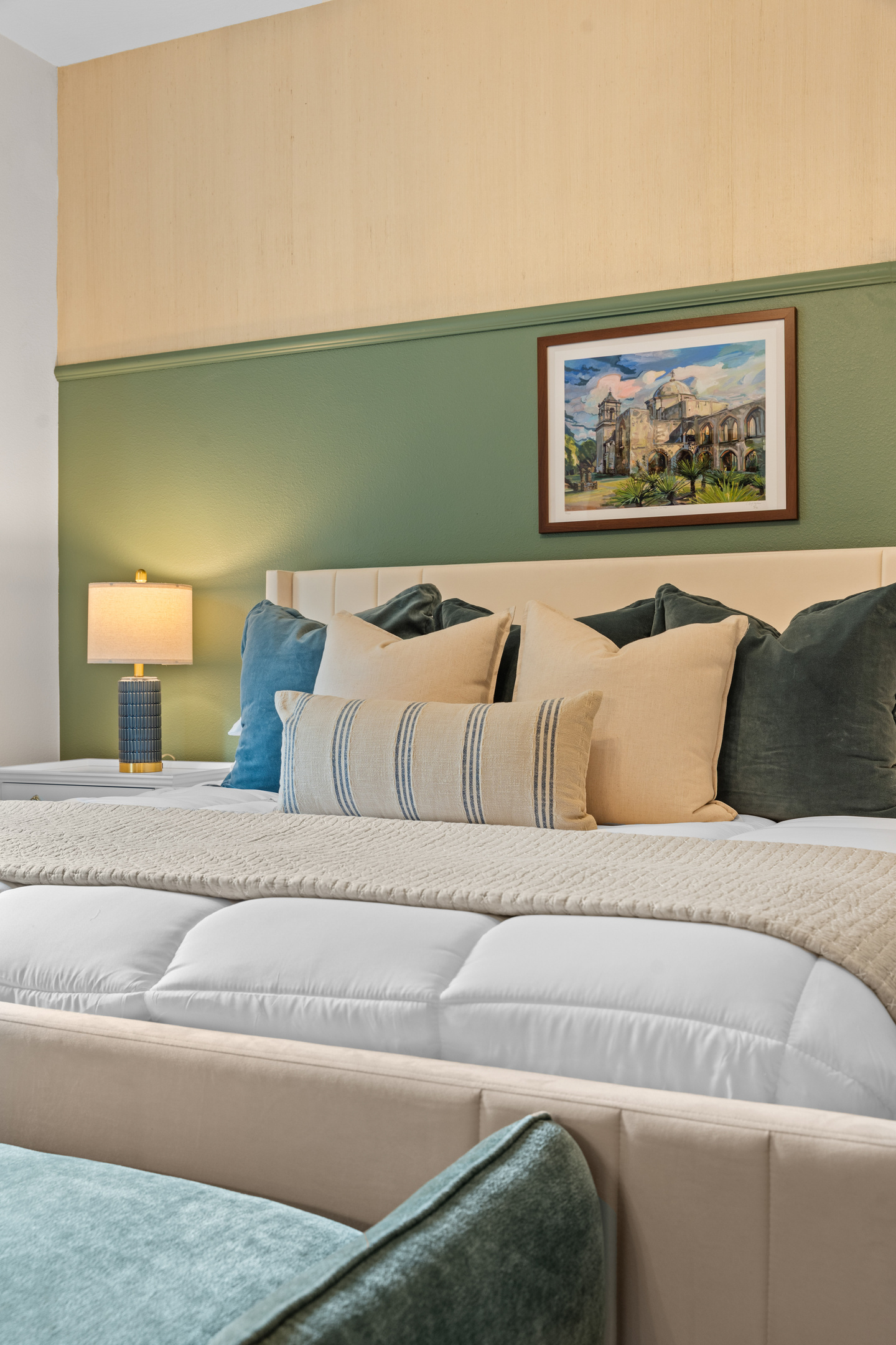 Layered linens and mission-inspired art bring quiet Texas charm to the San Antonio king bed.
