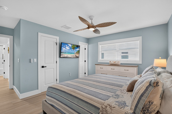 The peaceful primary bedroom features a new king mattress, relaxing coastal style and a 50-inch smart TV.