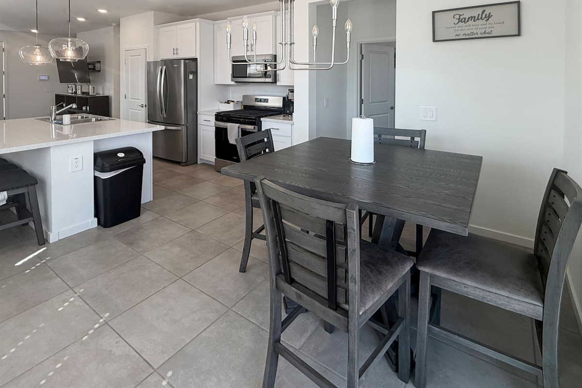 Dining table beside kitchen with four chairs