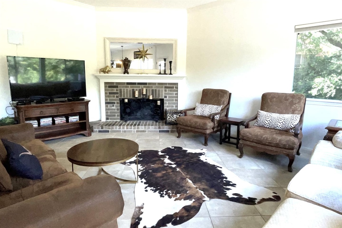 This stylish living space features generous seating,  an entertainment center that includes a 65-inch LED TV,  Roku and Apple TV for streaming, antenna for live TV, DVD player and DVDS, a beverage cart.