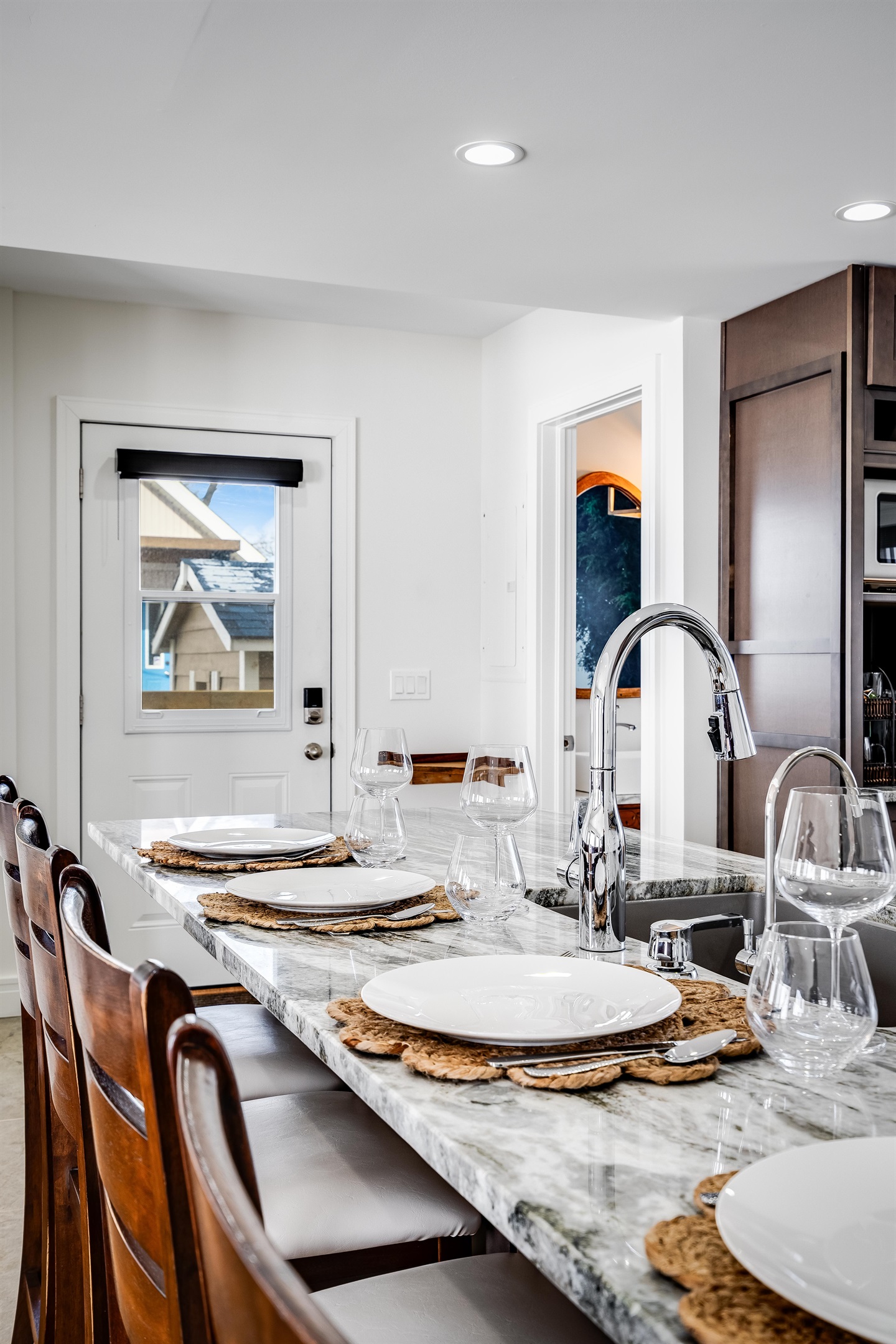  White walls shimmer like morning light, grounded by wood’s steady embrace.