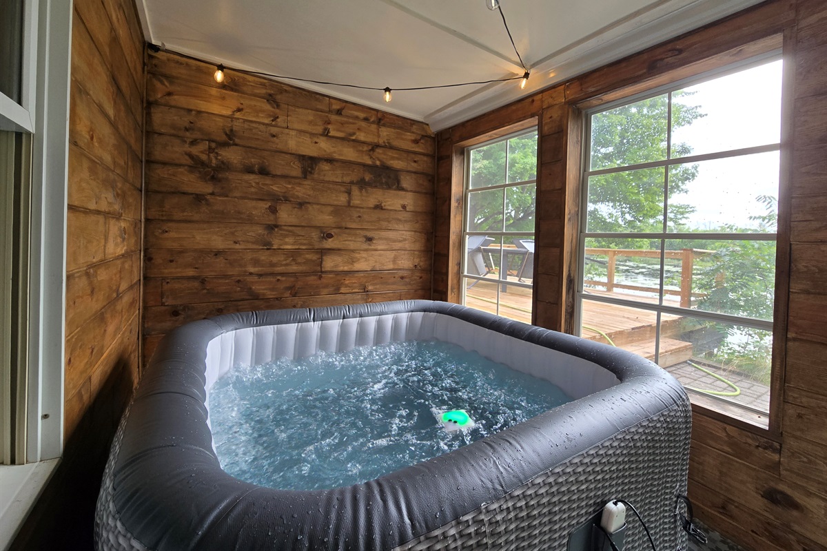 Unwind in the private hot tub overlooking the lake! 💦 Nestled in a warm cedar sunroom with glowing string lights and big windows, it’s the perfect place to relax after a day of trails, water fun, or s’mores by the firepit.