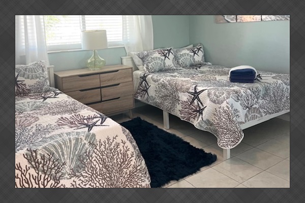 Guest bedroom with two full size beds and view of the Inlet