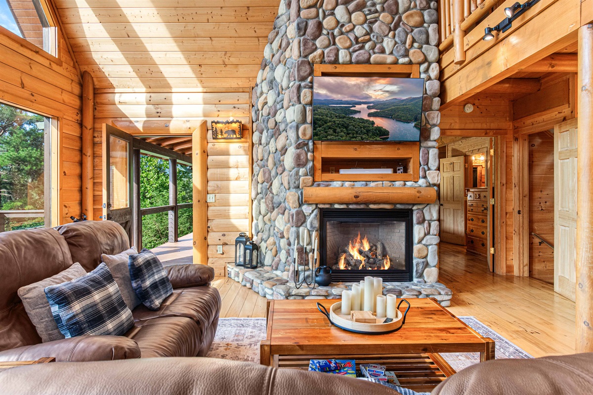 Main Level Living Room: Bask in the glow of the fireplace while enjoying scenic views and rustic charm!