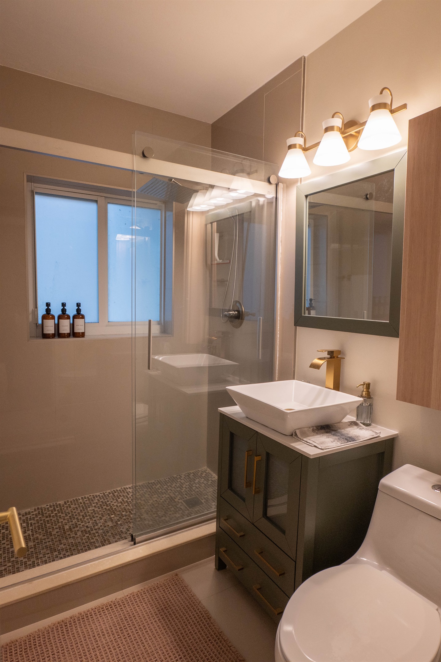 Full bathroom with walk-in shower, rainfall showerhead, toiletries and travel essentials provided