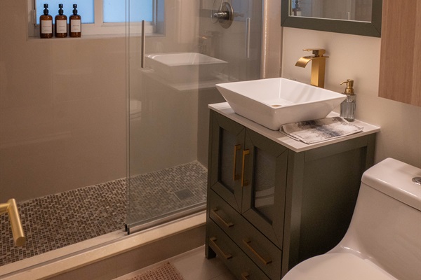 Full bathroom with walk-in shower, rainfall showerhead, toiletries and travel essentials provided