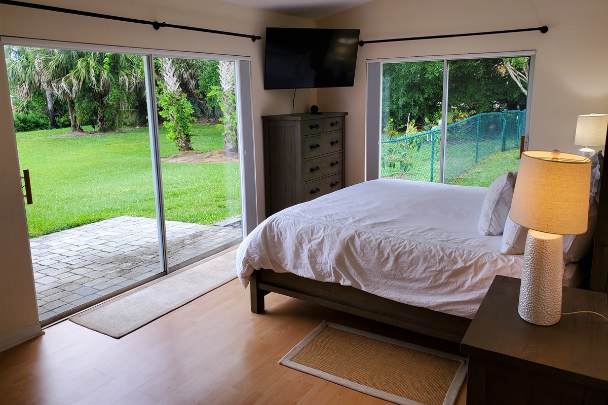 Master King bedroom with smart TV and access to backyard
