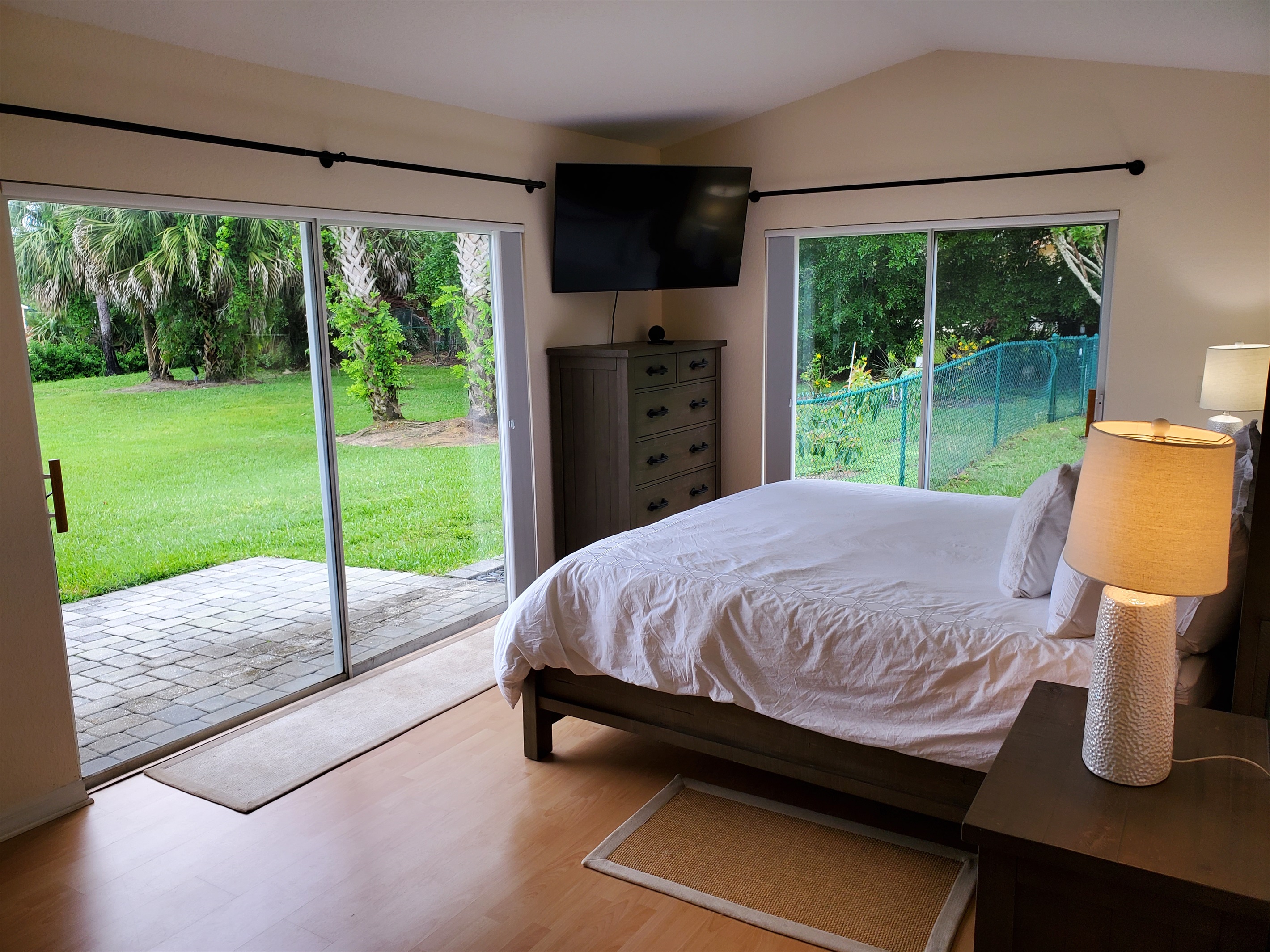 Master King bedroom with smart TV and access to backyard