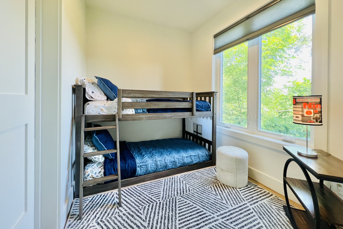 The kids may claim this room as their own.
Twin-over-twin bunks, a dedicated desk space, and easy access to the adjoining bathroom make this lower-level bunk room a fun and comfortable retreat for younger guests at Hidden Point House.