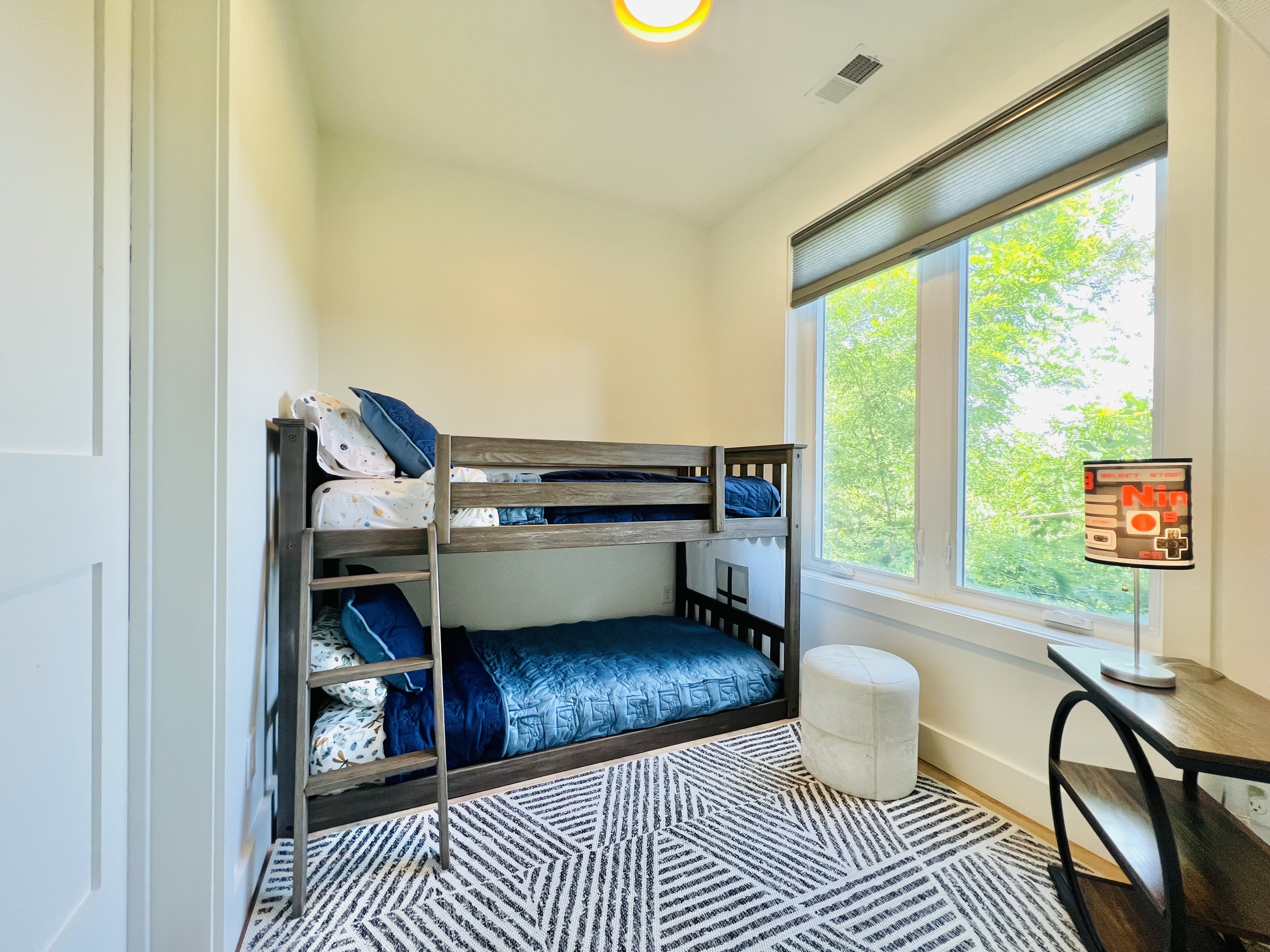 The kids may claim this room as their own.
Twin-over-twin bunks, a dedicated desk space, and easy access to the adjoining bathroom make this lower-level bunk room a fun and comfortable retreat for younger guests at Hidden Point House.