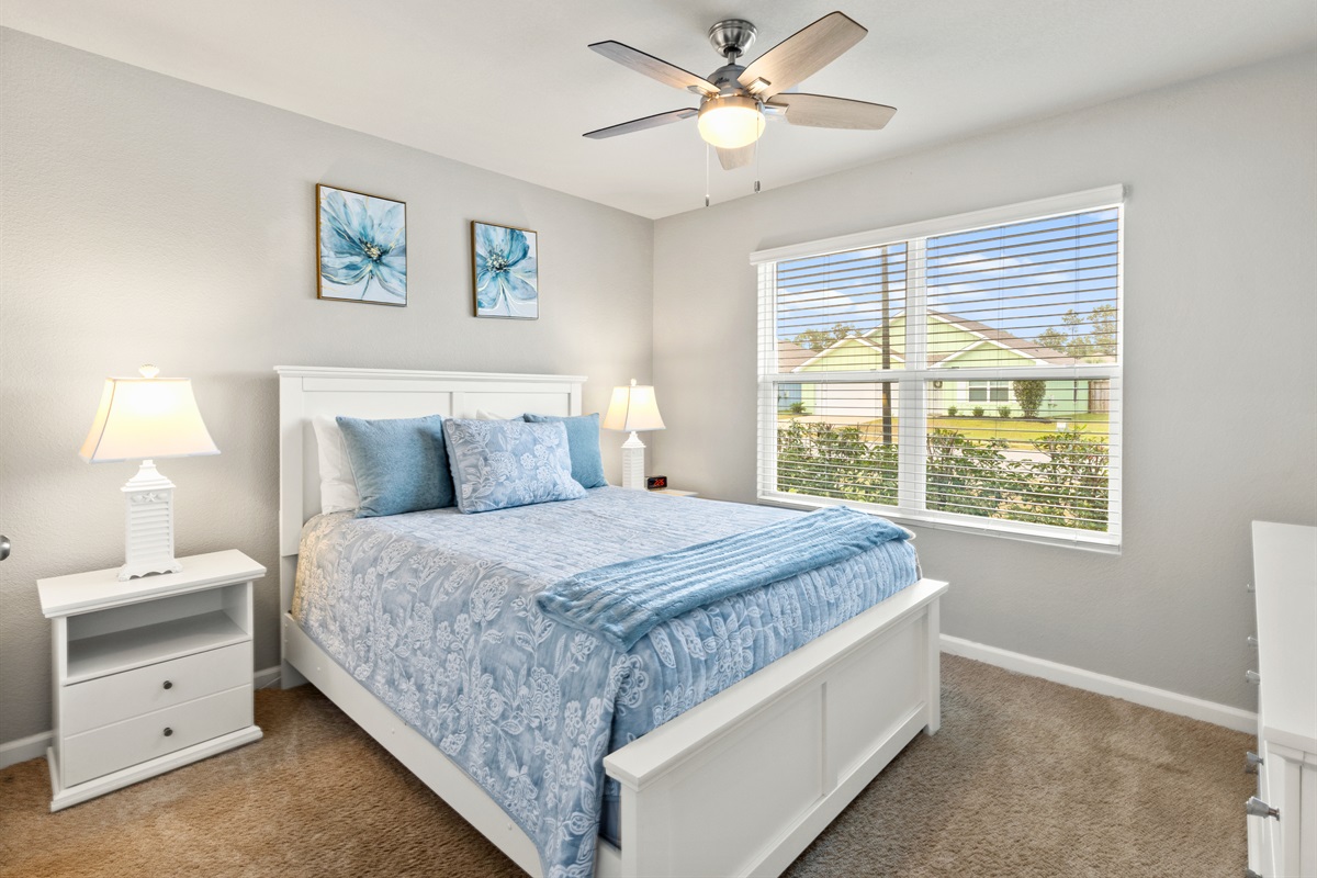 Another queen bedroom with natural light and soft blues, perfect for family or friends.