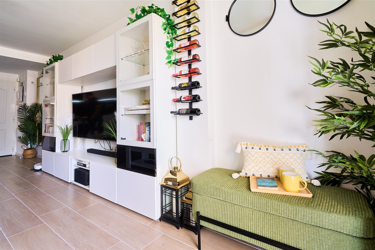 Stylish open-plan living room with a modern kitchen, smart TV, and natural light throughout — ideal for relaxing or sharing a glass of wine after a day by the beach.