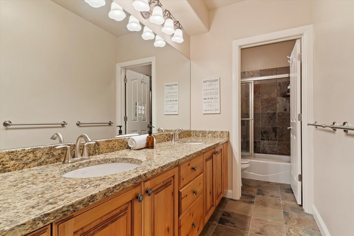 A well-appointed bathroom with dual vanities and granite finishes, combining style and convenience for multiple guests.