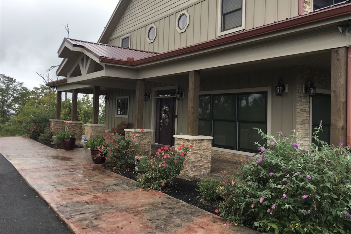 The entryway has a large driveway and welcoming landscaping to greet you.