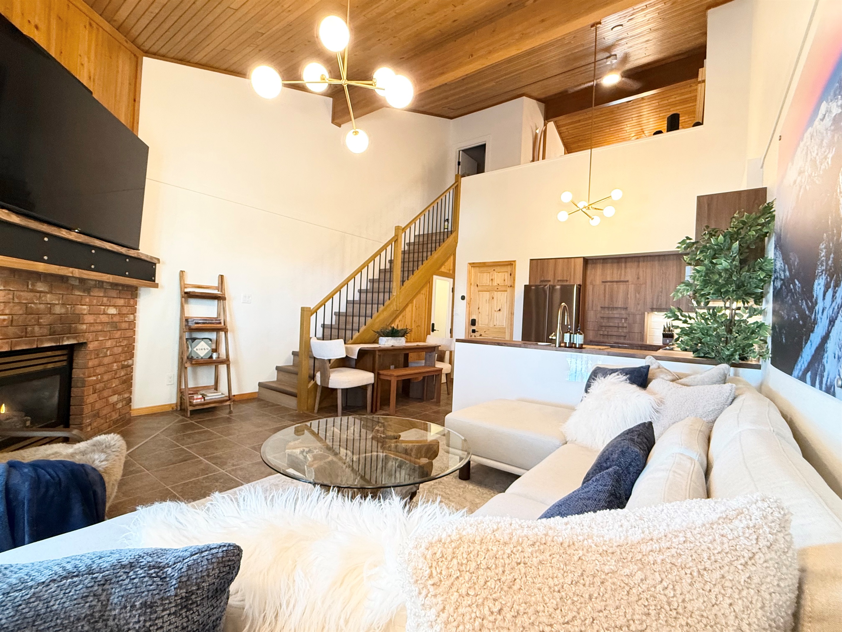Mountain Retreat Comfort: This living area connects seamlessly to the kitchen and loft, offering a welcoming atmosphere and a cozy gas fireplace for your mountain getaway.