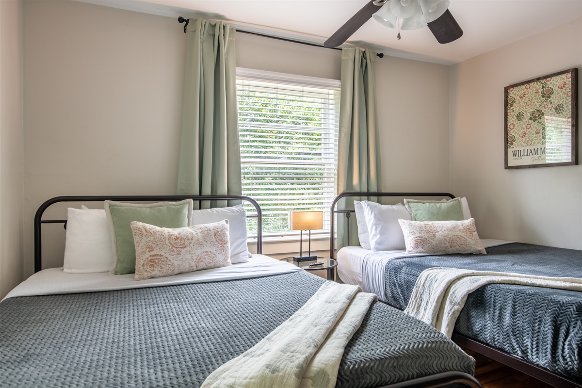 Chic twin bedroom with large windows, perfect for restful nights and refreshing mornings.