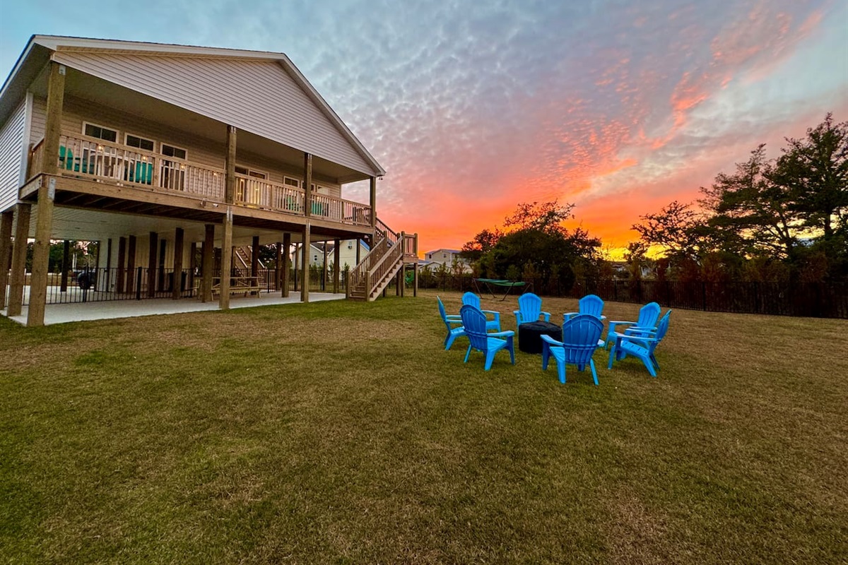 Private backyard dock with boat lift and fillet table, fenced-in backyard, fire pit with Adirondack chairs, hammocks, propane grill, picnic table, outdoor shower, expansive waterfront back deck, neighborhood boat ramp and dock