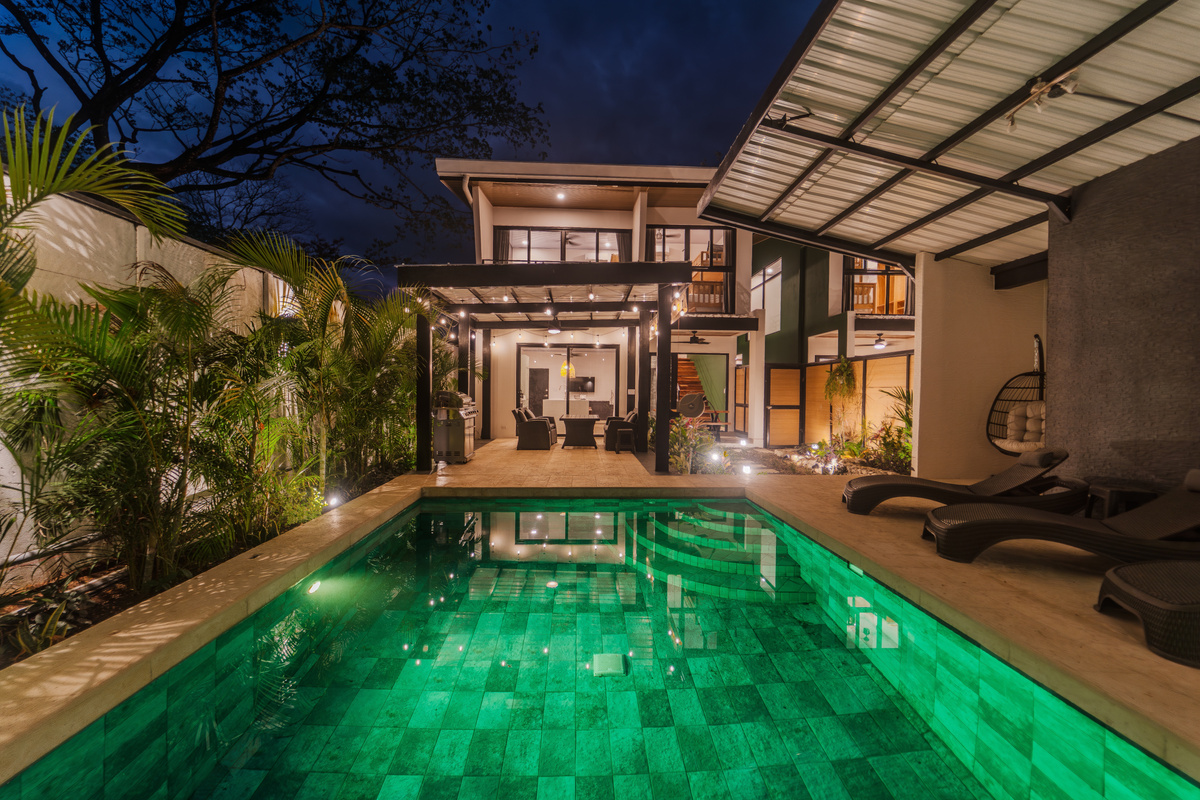 Pool at night — warm water, stars overhead, palm trees lit up. 