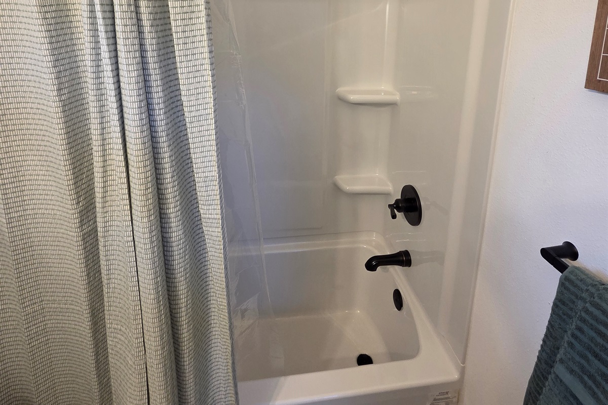 Bathroom includes vanity, toilet, and shower/tub combo.