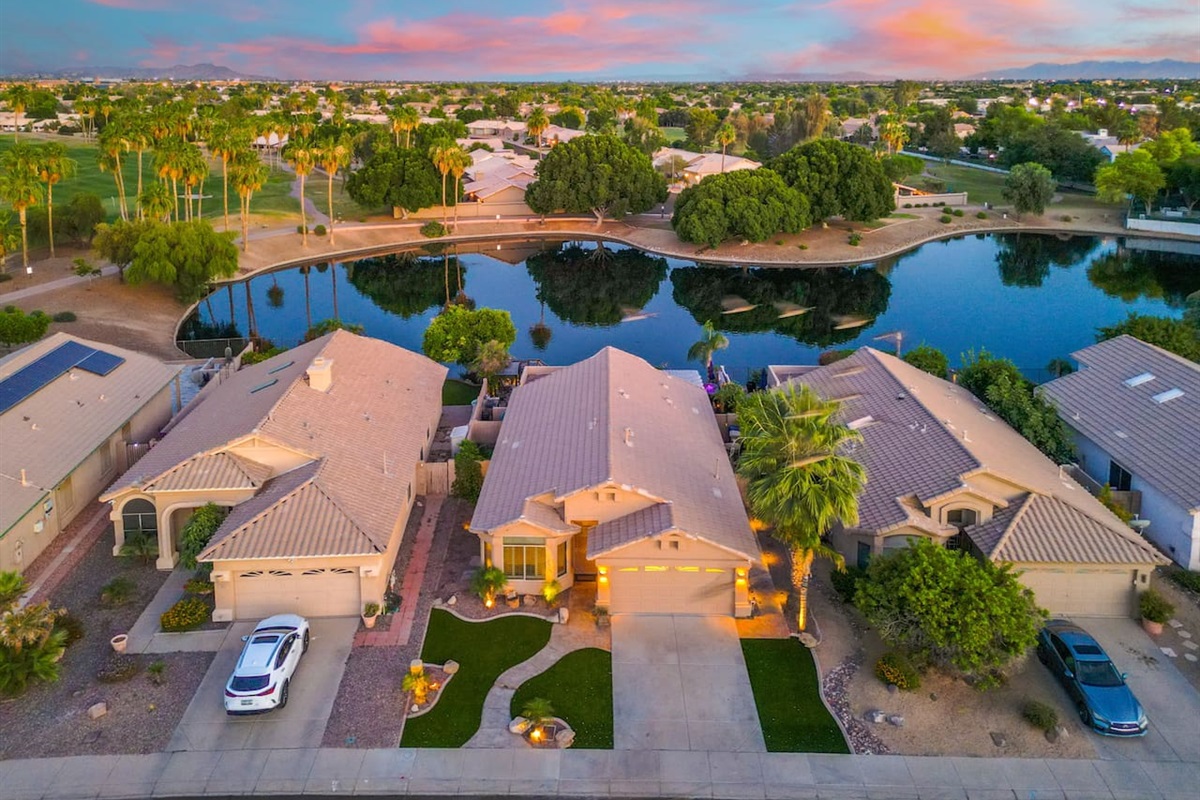 From the front curb to the lakeside backyard, the home delivers on every angle — lush turf, palm trees, a gleaming pool, and a front-row seat to Arizona's famous sunsets.