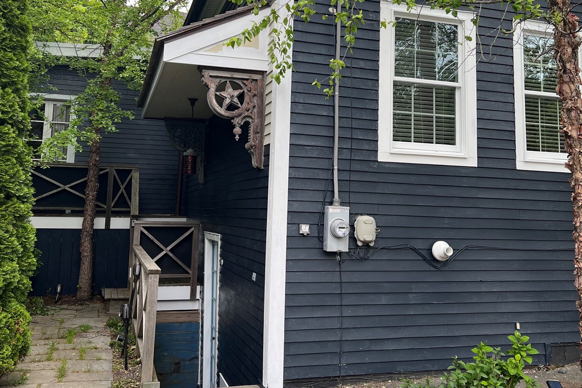 Private Outdoor Oasis: Dedicated patio with grill and seating nestled behind mature cedars. This space connects the upper balcony deck off the primary King wing to the direct-access stairs leading to our ship-inspired "Below Deck" dining area.